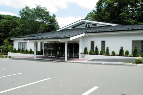 豊かな緑に抱かれて建つ上川緑葉会館。